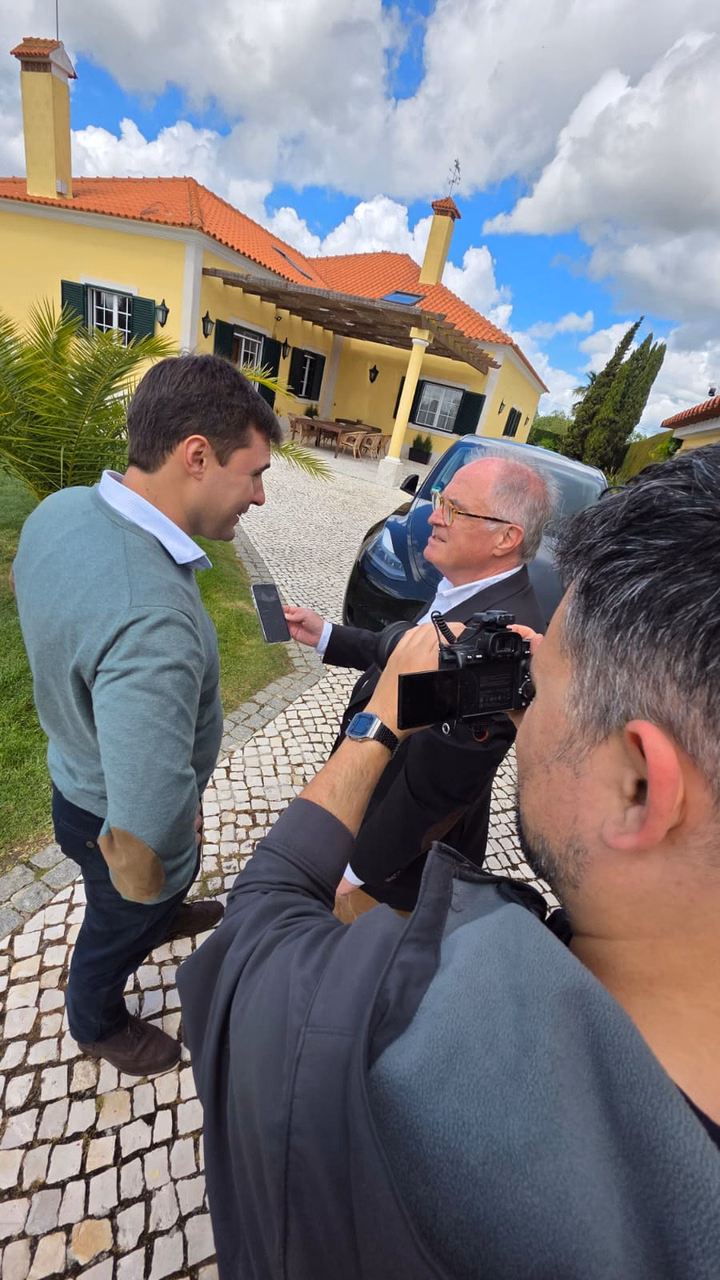 Luis Neves is interviewed by a camera crew in front of his solar-powered home in Lisbon.