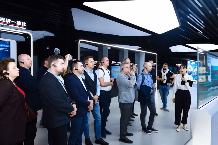 LONGi and KENO partners tour manufacturing facility with guide.