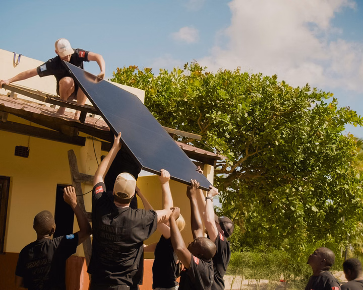 Team installing solar panels on a rural clinic roof in Mozambique.