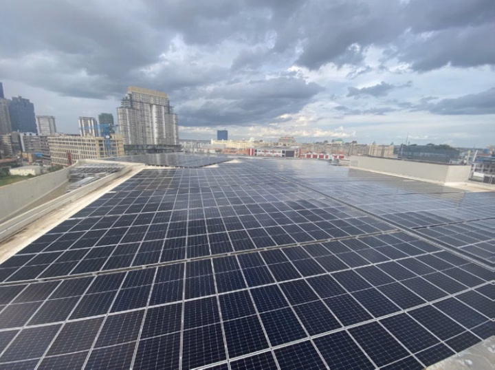 Aeon Mall rooftop covered in solar panels with city buildings in the background.