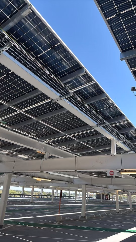 Low-angle view of anti-glare solar panels installed on the Ghent University Hospital parking structure roof.