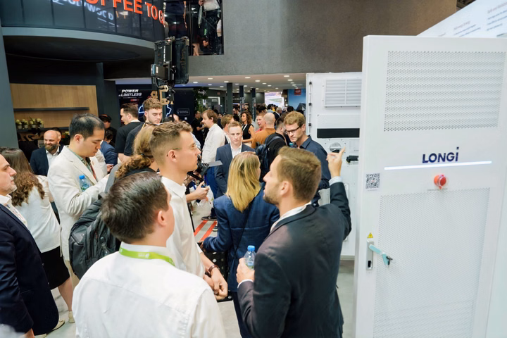 Professional team discussing energy storage systems at the LONGi booth during Intersolar Europe.