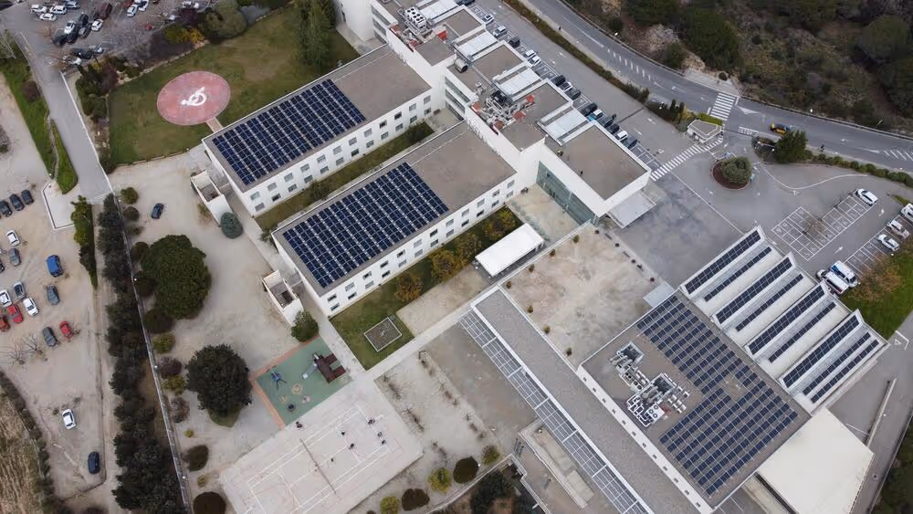 Aerial view of Guttmann Institute rooftops with LONGi Hi-MO X6 solar panels.