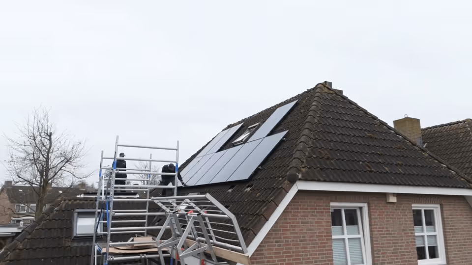 Technicians installing sleek black LONGi Artist solar panels on a residential roof.