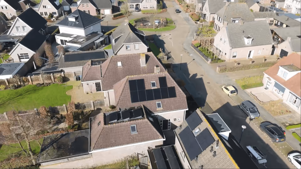 Aerial view of a home in the Netherlands featuring sleek LONGi Artist solar panels on the roof.
